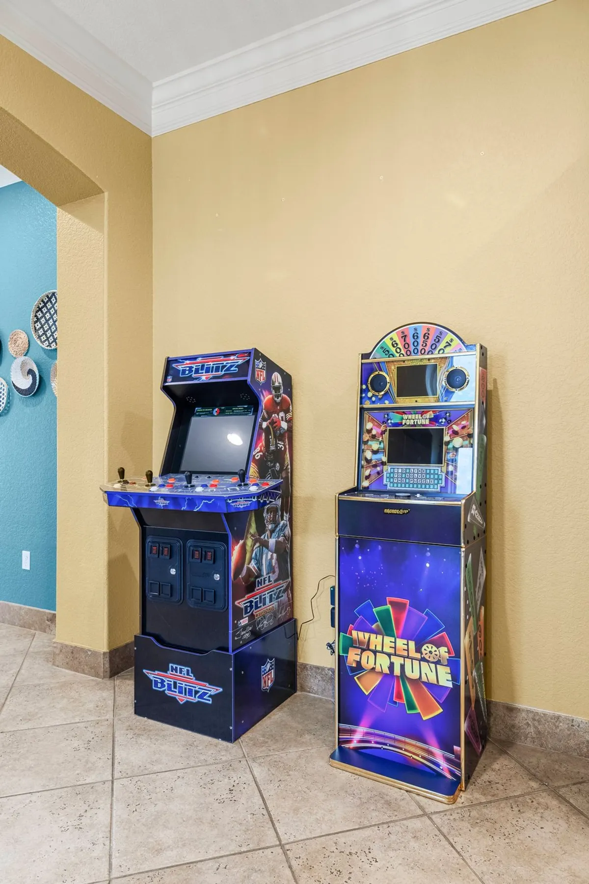 This energetic interior scene features an arcade space with an NFL Blitz and Wheel of Fortune arcade machine, inviting guests to engage in family game nights and friendly competitions indoors.